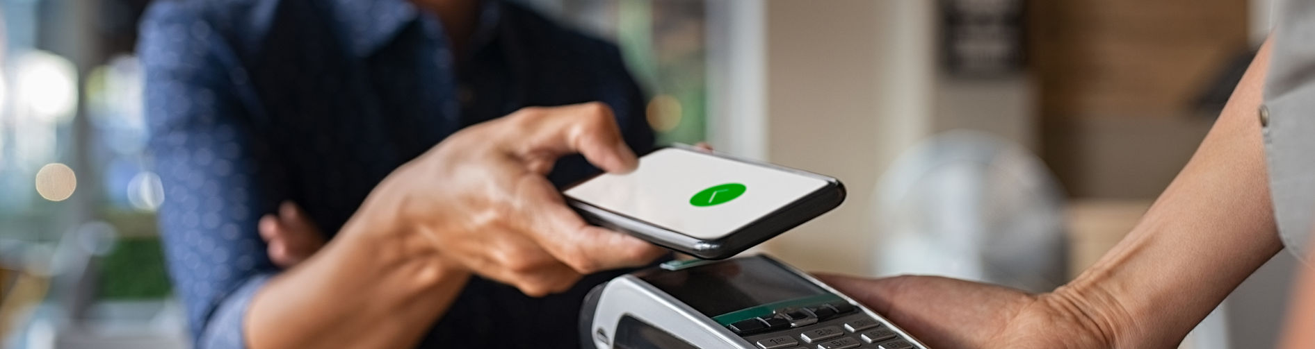 Customer making a contactless payment at a Safari Telecom counter